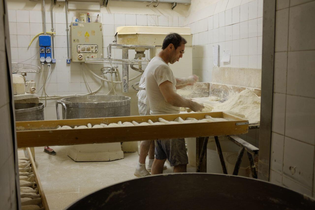 Preparing to put bread in an oven that has been baking since 1870