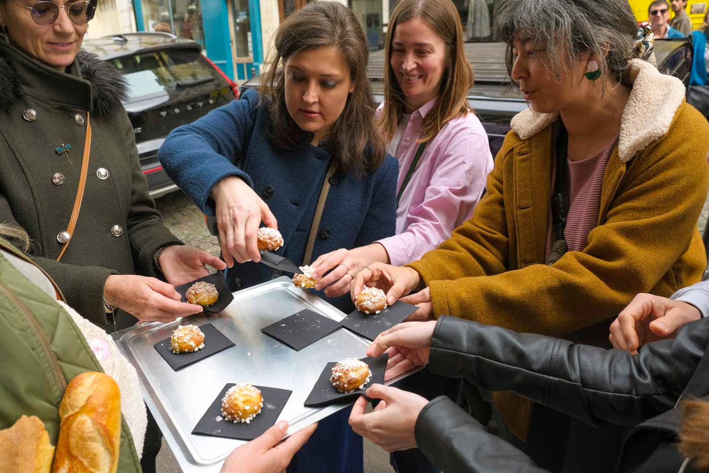 Tour_group_members_sampling_cream_puffs_at_Choupettes_de_ChouChou_Paris